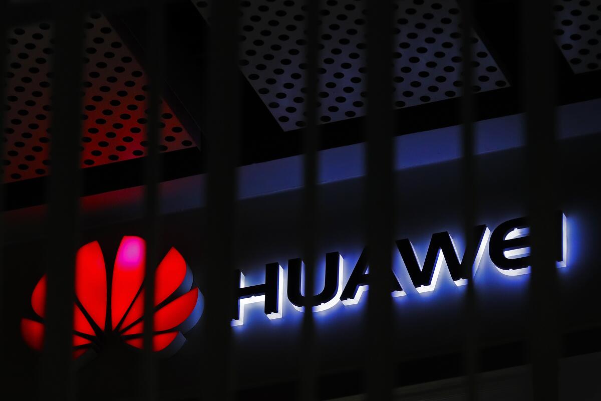 A logo of a Huawei retail shop is seen through a handrail at a Beijing office building.