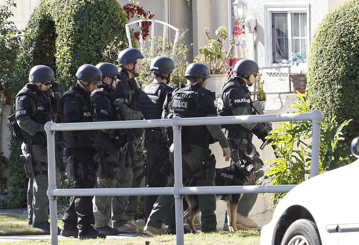 Glendale SWAT officers prepare to enter a backyard in the 600 block of West Concord St. to search for a home invasion robbery suspect on Wednesday, January 2, 2013.