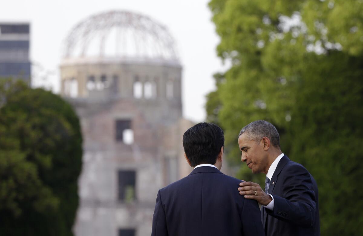 President Obama and Japanese Prime Minister Shinzo Abe speak with the Atomic Bomb Dome seen behind them at the Hiroshima Peace Memorial Park in Japan on Friday.