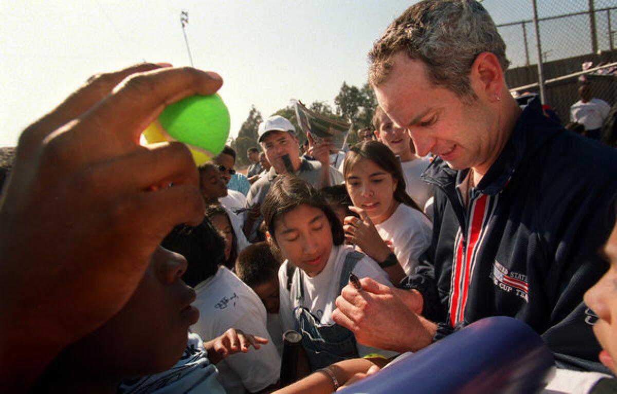 John Mcenroe signs autographs during a tennis clinic in Inglewood in 2000.