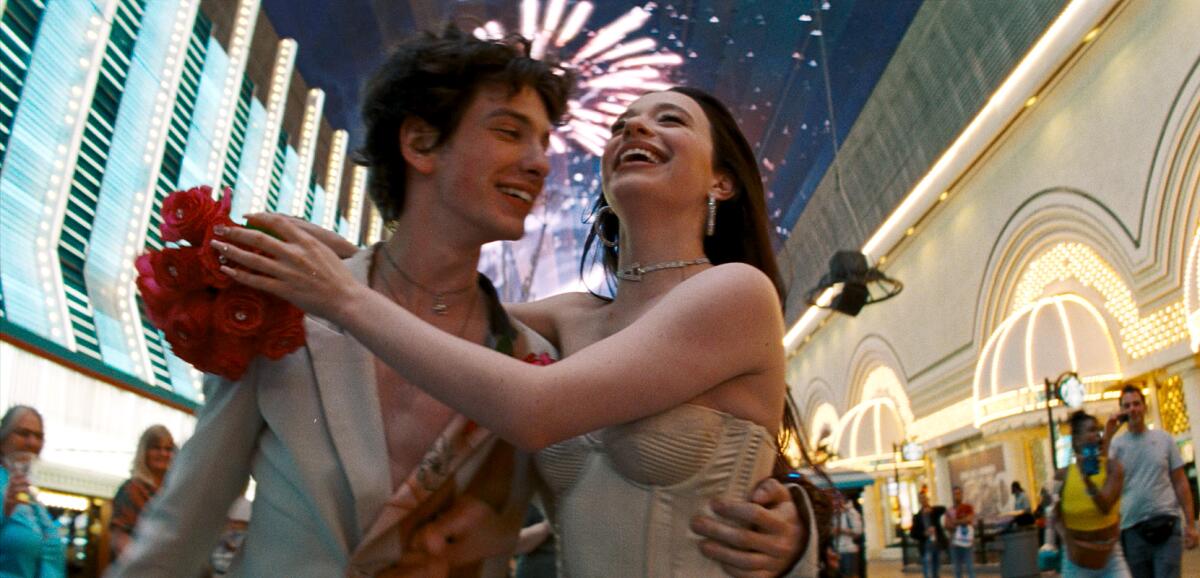 A young man and woman embrace on the bright streets of Las Vegas in "Anora."