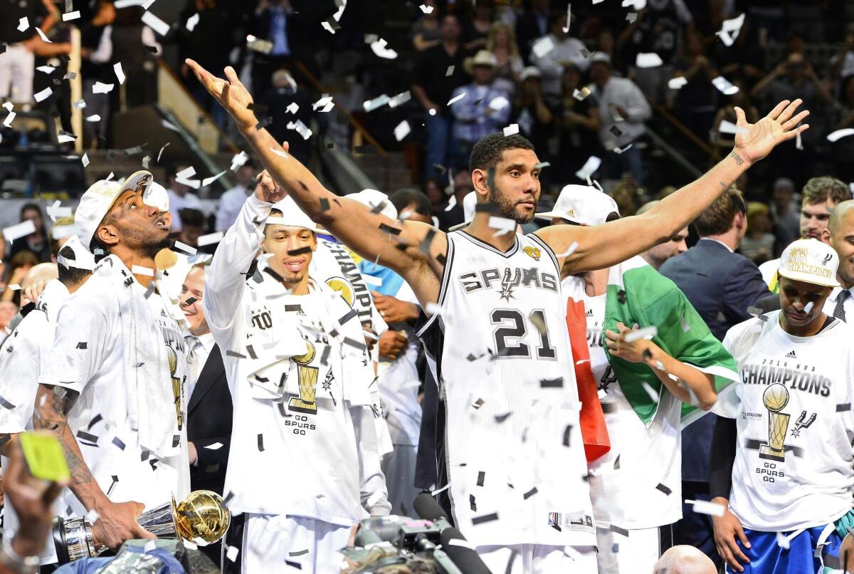 Tim Duncan raises his arms in celebration after winning his fifth NBA championship with a victory over the Miami Heat on Sunday at the AT&T Center in San Antonio.