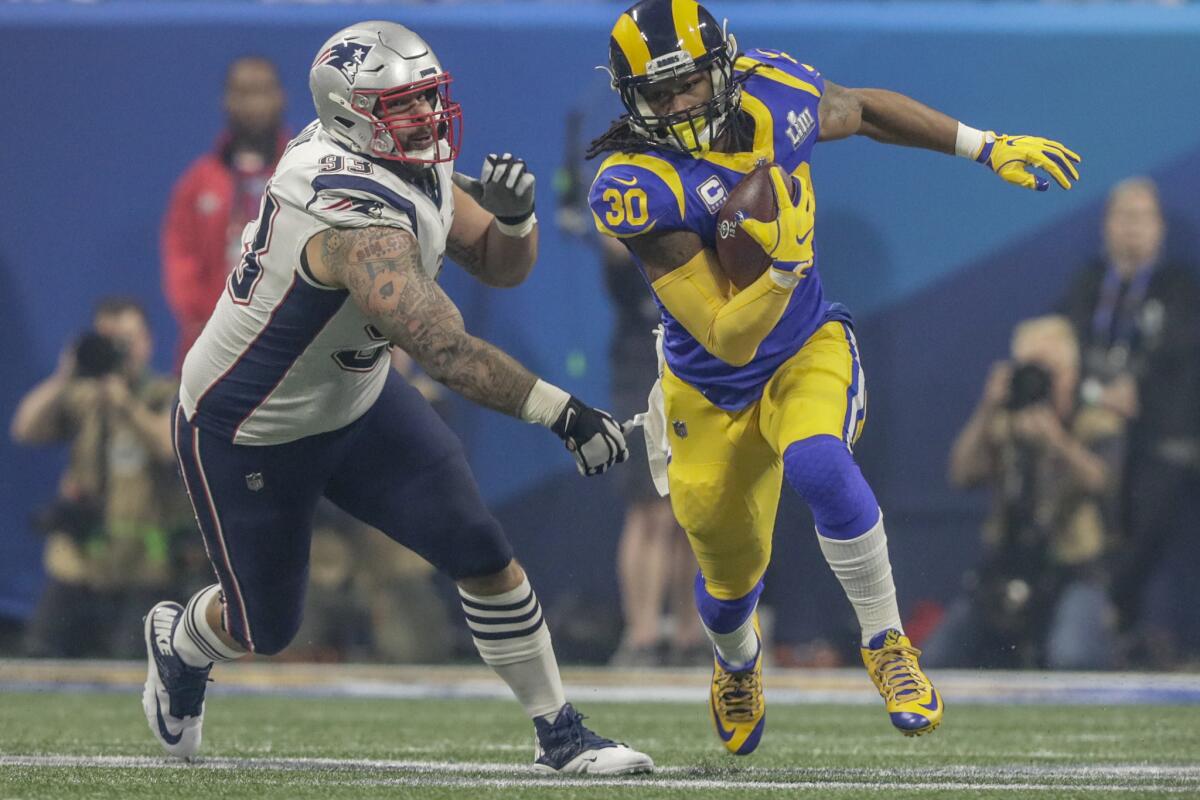 Rams running back Todd Gurley runs past a Patriots defensive lineman Larence Guy during Super Bowl LIII at Mercedes-Benz Stadium.