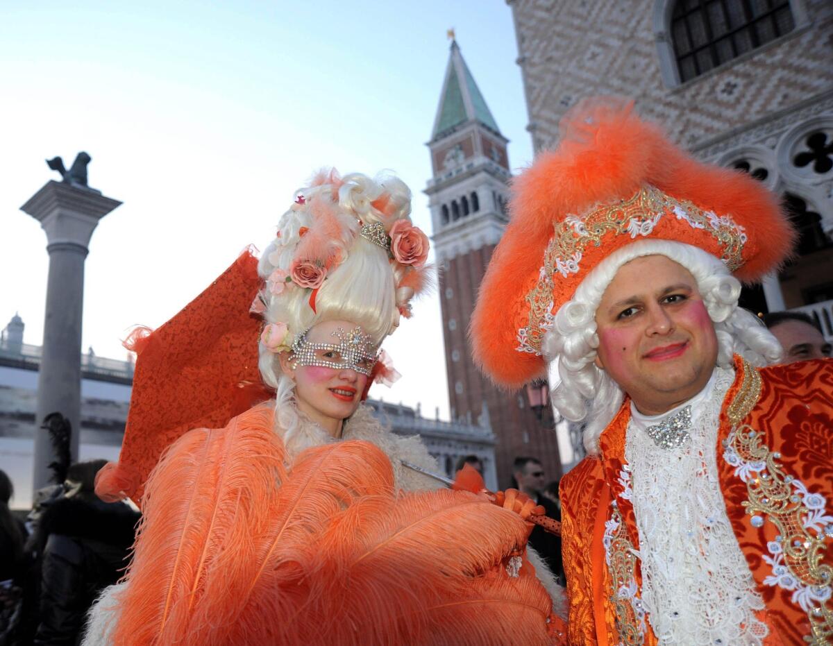 Two masked revelers in Saint Mark's Square during the Carnival celebrations in Venice, Italy.