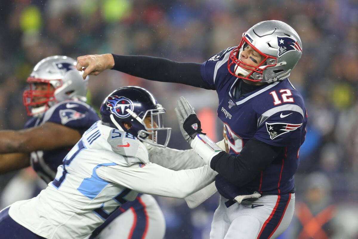 Patriots quarterback Tom Brady passes while being pressured by Titans linebacker Harold Landry in the second half Saturday night.