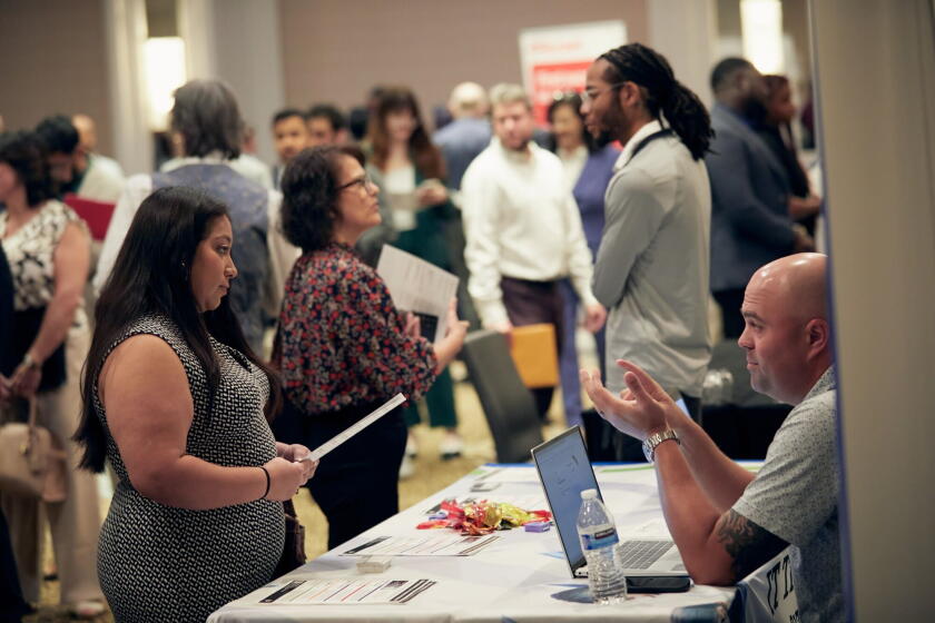 A jobseeker speaks with a recruiter during a job fair in Dallas.