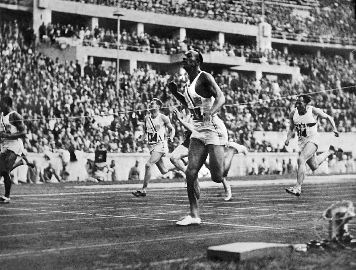 Jesse Owens crosses the finish line to win the 100-meter dash at the 1936 Olympics.