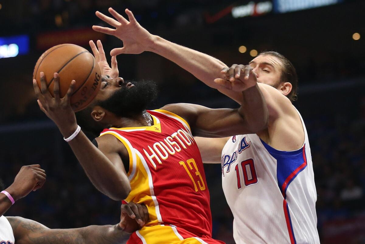 Rockets guard James Harden is challenged by Clippers center Spencer Hawes in the first half of Game 3.