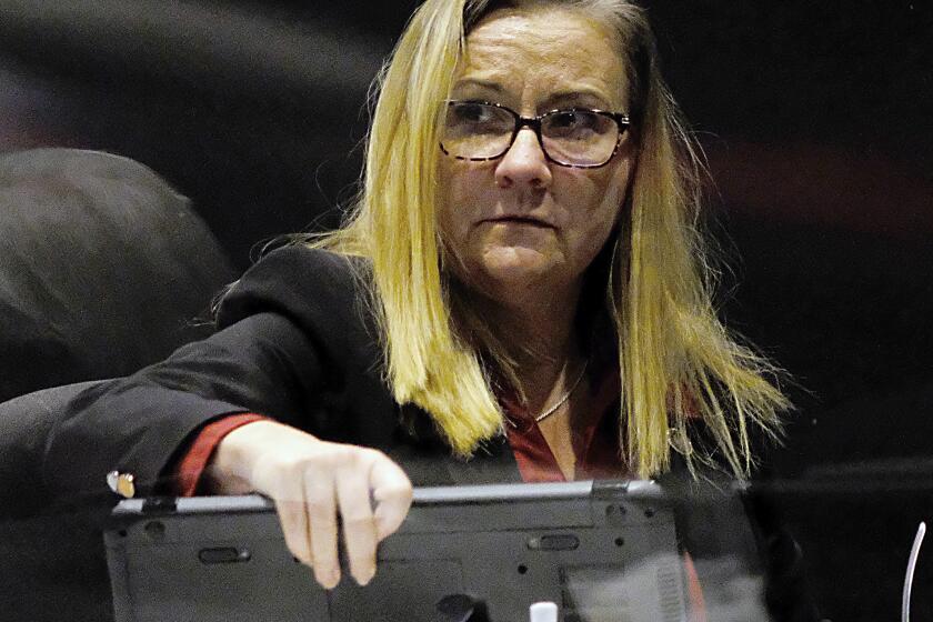 Sen. Amanda Chase, R-Chesterfield, packs up her computer as she prepares to leave during the floor session of the Virginia Senate inside the Science Museum in Richmond, Va., Tuesday, Jan. 26, 2021. She had asked that the censure resolution against her be put off for another day after announcing that her mother-in-law had open-heart surgery. The Senate members agreed to put the vote off for a day. (Bob Brown/Richmond Times-Dispatch via AP)