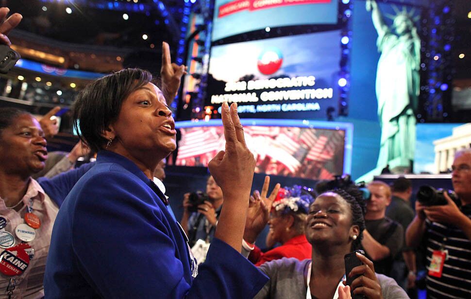 North Carolina delegate Ingrid Nurse, left, dances and sings of a second term for President Obama.