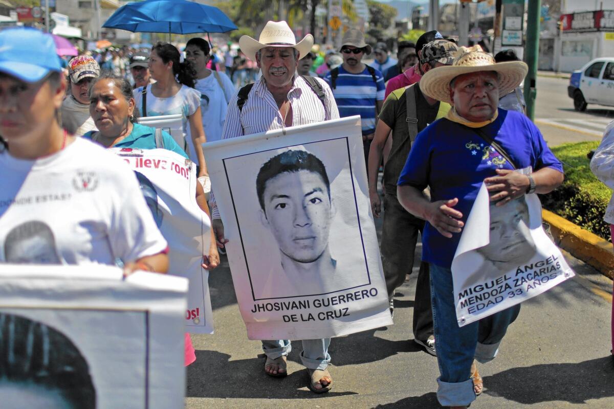 A relative holds a portrait of Jhosivani Guerrero de la Cruz, one of 43 missing Mexican students, during a March rally in Acapulco. Mexican authorities said they have identified his remains.