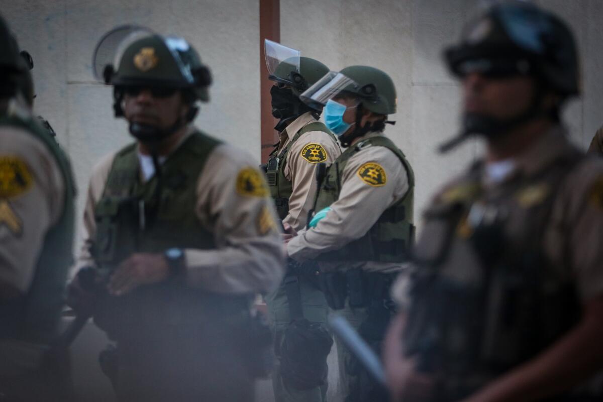 Deputies stand guard during a protest outside the sheriff's station in Compton on June 21.
