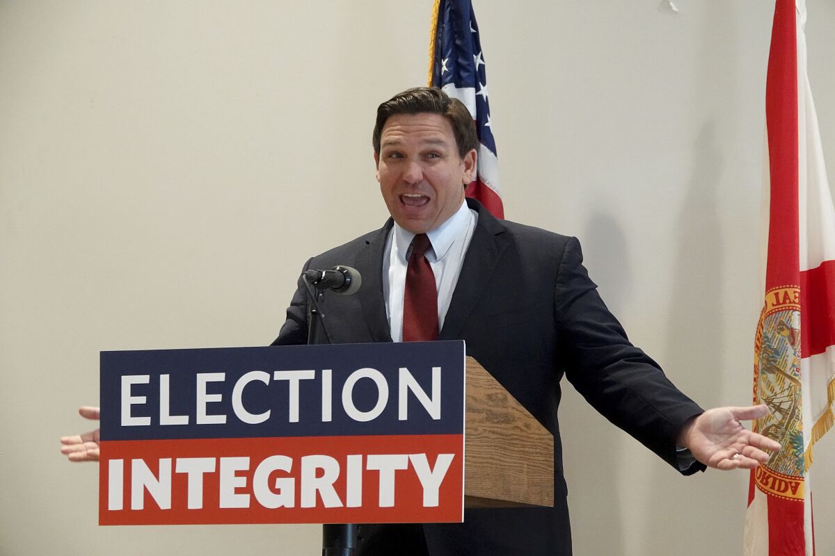 FILE - Florida Gov. Ron DeSantis asks the crowd "How about Virginia," as he arrives at an event in West Palm Beach, Fla., to announce proposed election reform laws, Wednesday, Nov. 3, 2021. Republicans promoting claims of widespread voter fraud in at least two politically important states are turning to a new tactic to appease voters who falsely believe the 2020 presidential election was stolen: election police. The efforts in Florida and Georgia to establish law enforcement units dedicated to investigating voting or election crimes come as Republican lawmakers and governors move to satisfy the millions of voters in their party who believe former President Donald Trump’s false claims that widespread voter fraud cost him re-election. (Joe Cavaretta/South Florida Sun-Sentinel via AP)