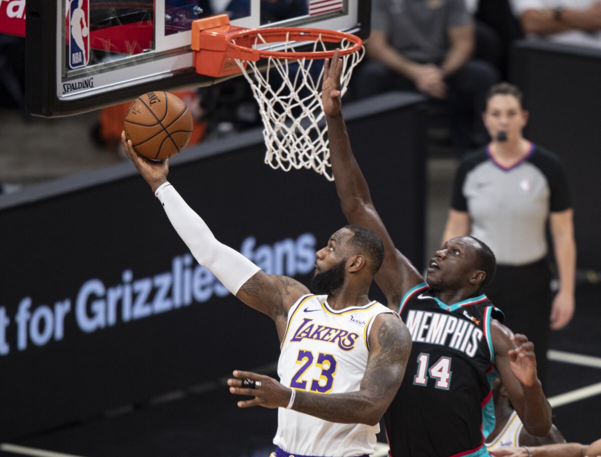 Lakers forward LeBron James attempts a layup against Grizzlies center Gorgui Dieng in the first half of a game Jan. 3, 2021.