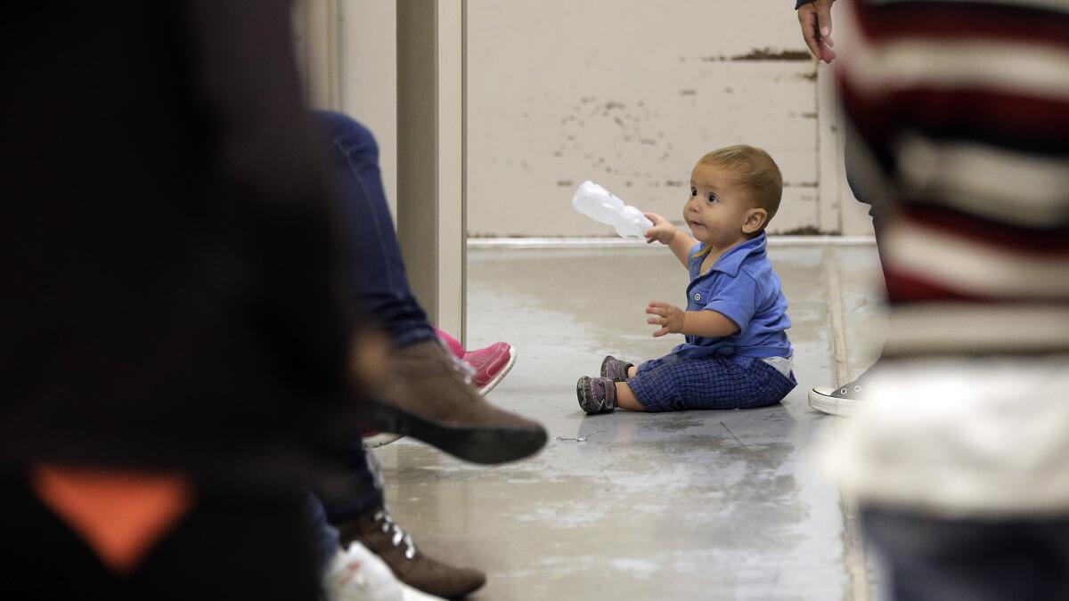 A toddler sits on the floor at a U.S. Customs and Border Protection processing facility in Brownsville, Texas.