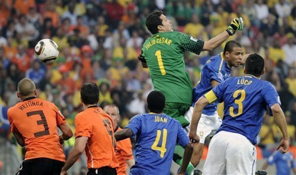 Brazil's Felipe Melo, second from right, scores an own goal against Brazil goalkeeper Julio Cesar, top, during the World Cup quarterfinal soccer match between the Netherlands and Brazil at Nelson Mandela Bay Stadium in Port Elizabeth, South Africa, Friday, July 2, 2010. (AP Photo/Martin Meissner)