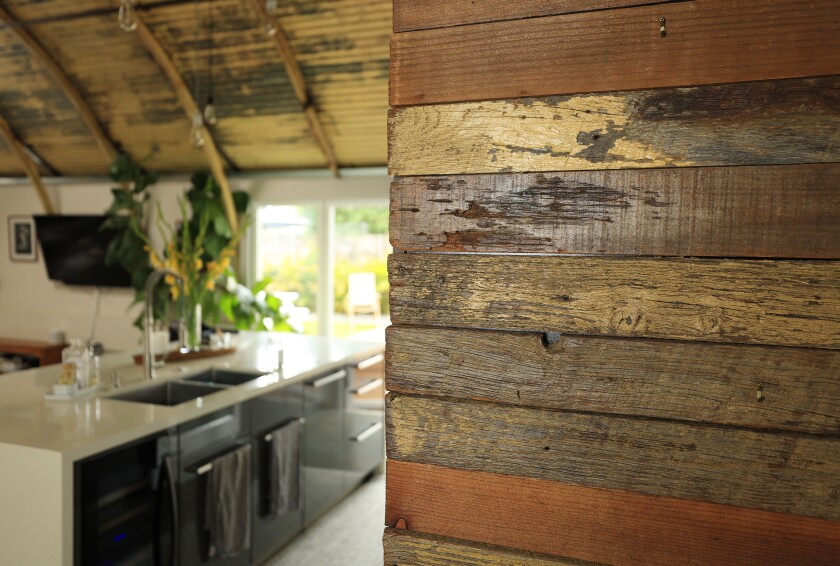 Treated wood lines the walls in the kitchen of the transformed Quonset hut.