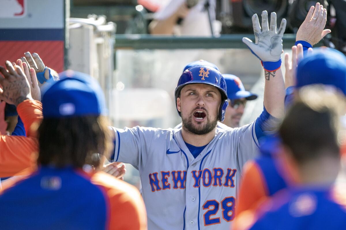 New York Mets designated hitter J.D. Davis, center, reacts as he is congratulated in the dugout after hitting a solo home run against the Los Angeles Angels during the fourth inning of a baseball game in Anaheim, Calif., Sunday, June 12, 2022. (AP Photo/Alex Gallardo)