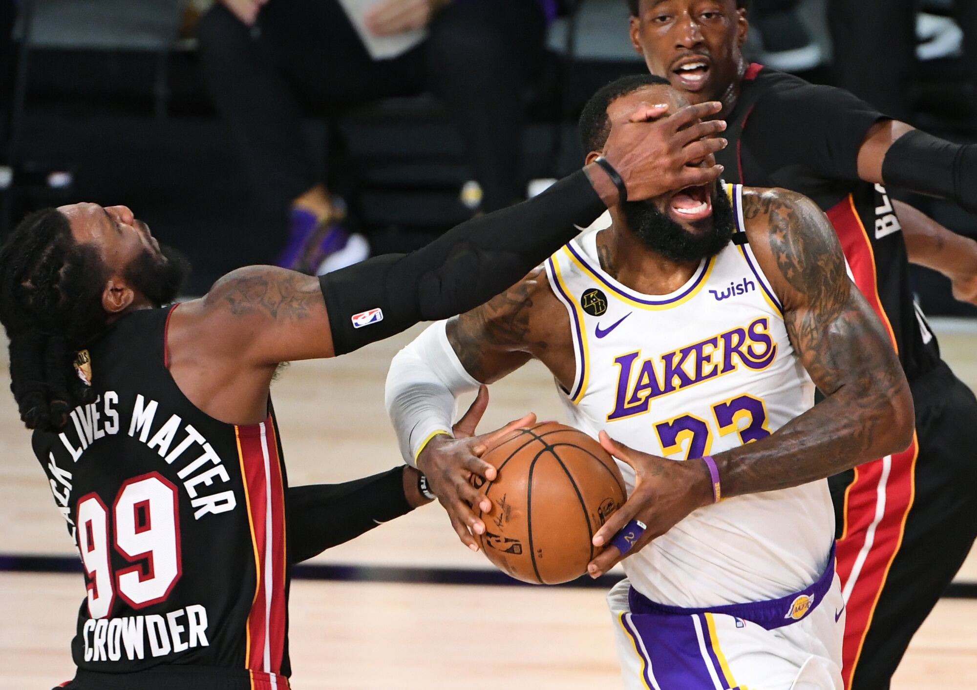 Lakers forward LeBron James is hit in the face by Miami Heat forward Jae Crowder while driving to the basket.