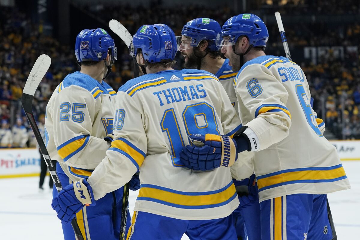 St. Louis Blues players celebrate after a goal against the Nashville Predators in the third period of an NHL hockey game Saturday, March 12, 2022, in Nashville, Tenn. (AP Photo/Mark Humphrey)