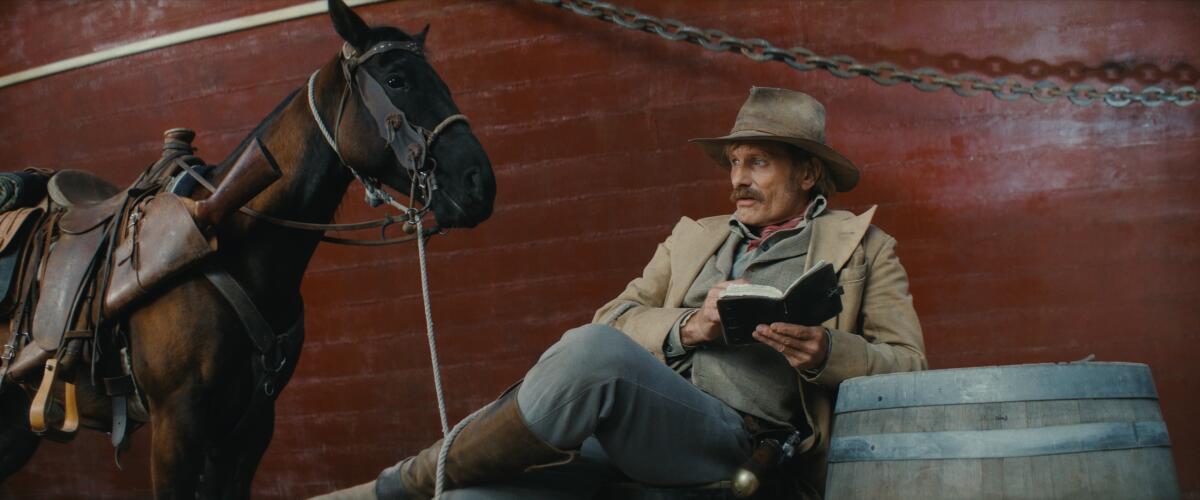 A cowboy reads a book in the Old West.