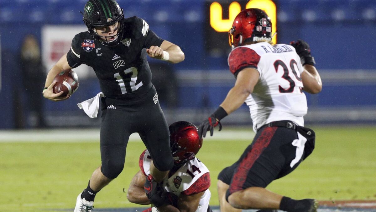 Ohio quarterback Nathan Rourke (12) gets tackled by San Diego State safety Tariq Thompson (14) in the first half of the Frisco Bowl on Wednesday in Frisco, Texas.