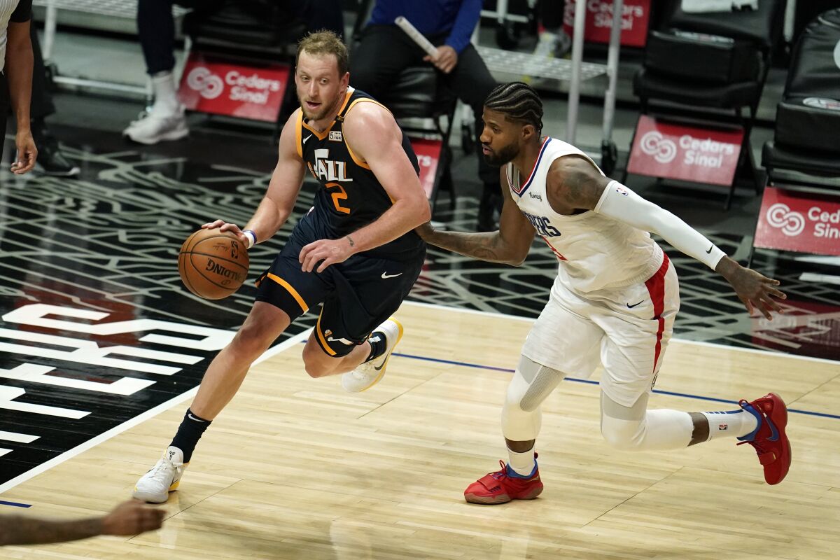 Utah Jazz forward Joe Ingles dribbles past Clippers guard Paul George.