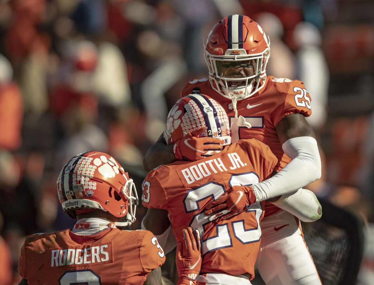 Clemson safety Jalyn Phillips (25) celebrates a defensive stop with cornerback Andrew Booth Jr. (23) during the second half of an NCAA college football game Saturday, Oct. 31, 2020, in Clemson, S.C. (Josh Morgan/Pool Photo via AP)