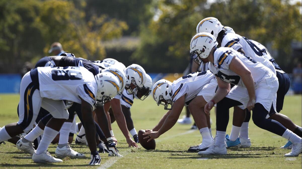 Chargers players run a drill during practice in Costa Mesa.