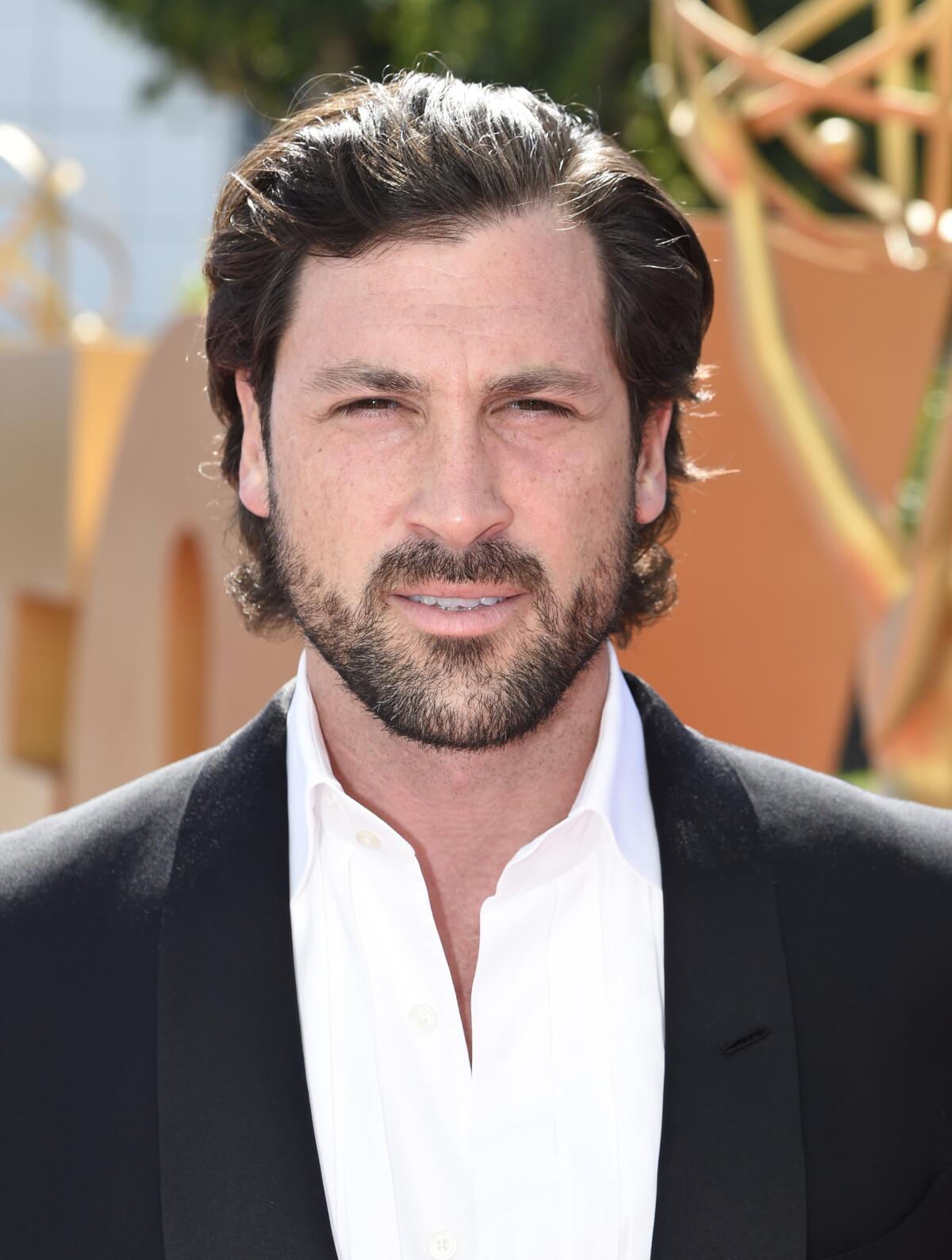 A man in a shawl-collar tuxedo on a sunny day.