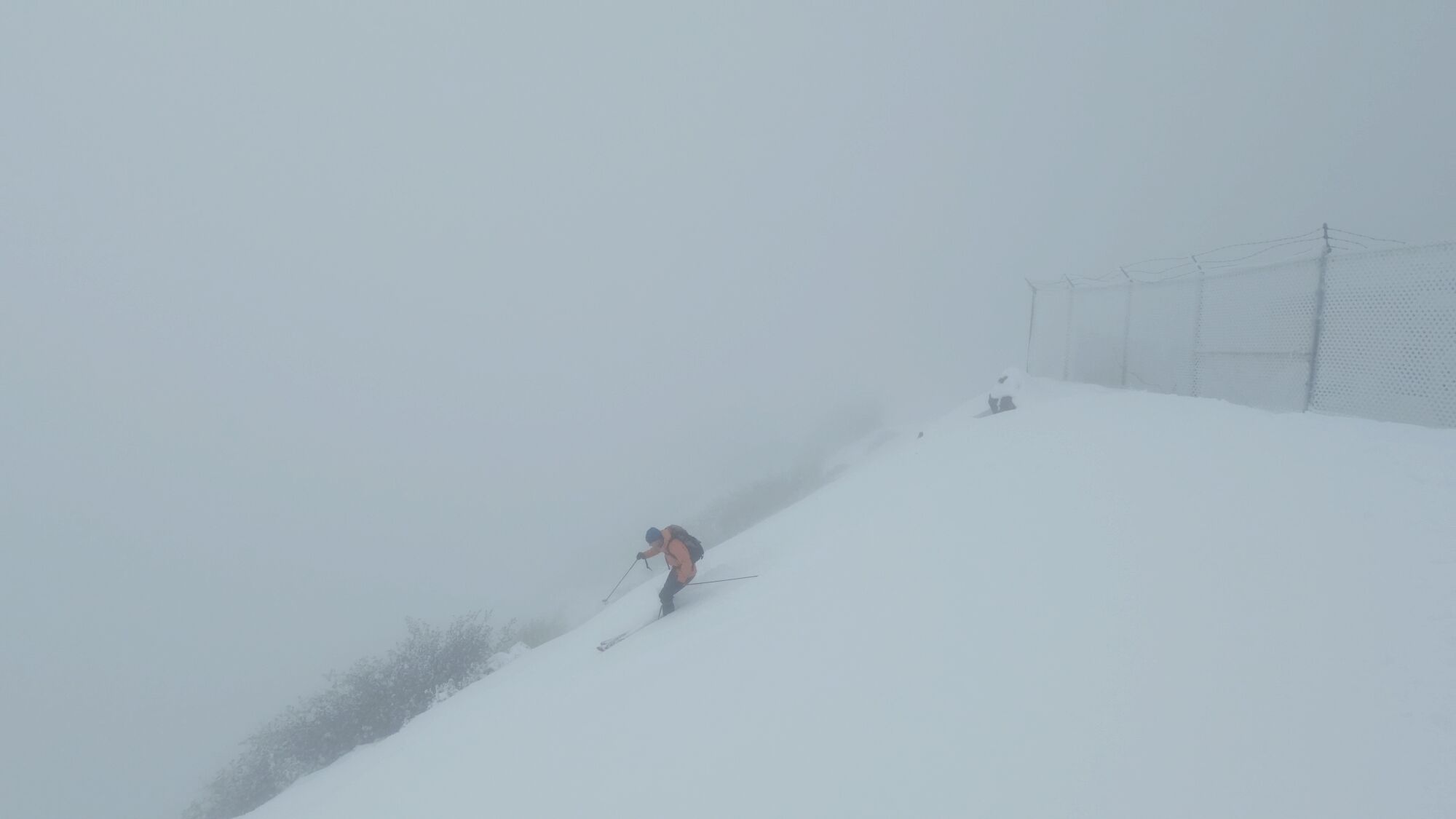 A skier begins his run down the fog-shrouded west face of Mt. Lukens.