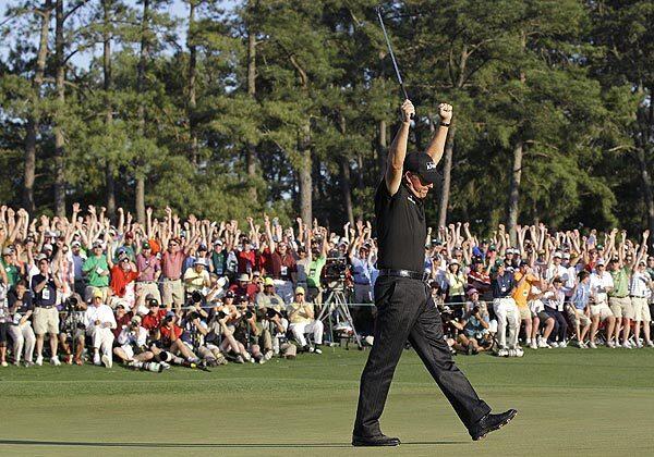 Phil Mickelson celebrates on the 18th green after winning the Masters golf tournament. It was Mickelson's third Masters title.