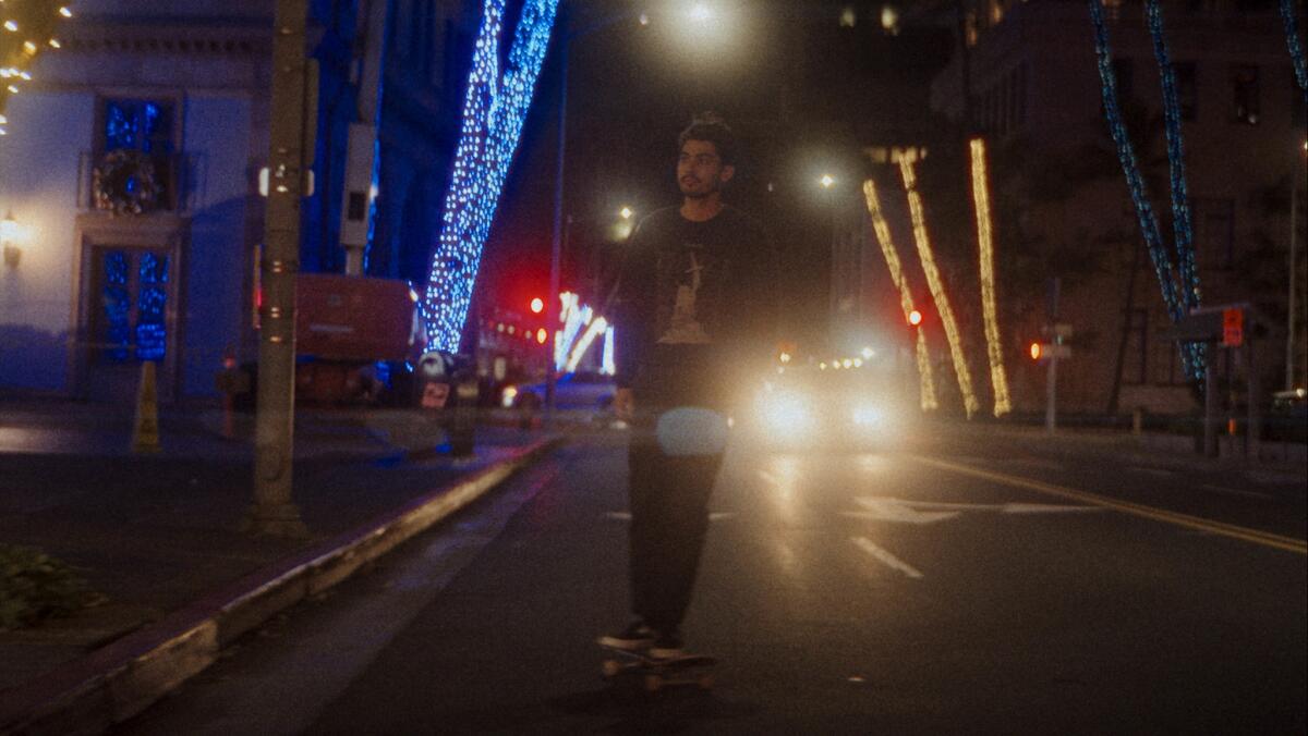 A man stands in the middle of the street at night 