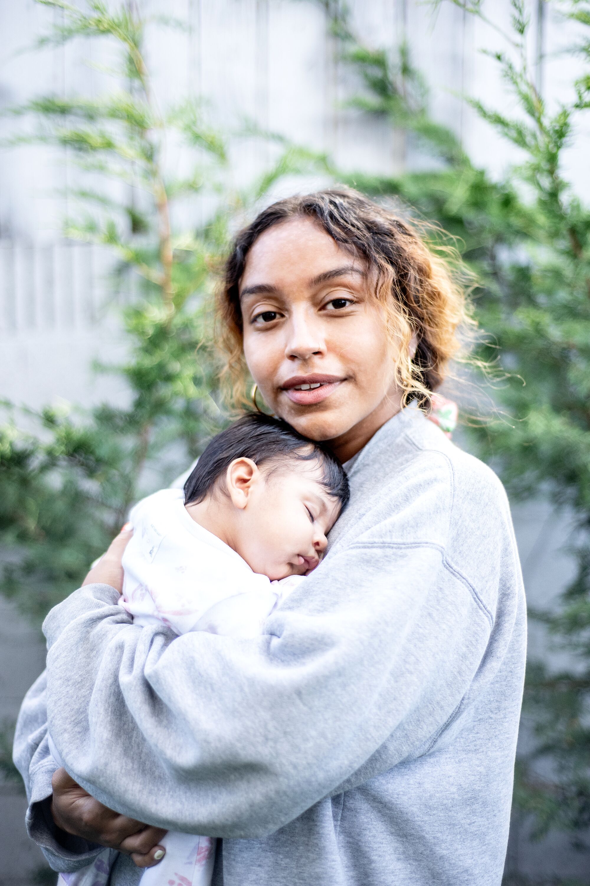 Portrait of Evelynn Escobar and her baby, Isla Andrade-Escobar in the backyard of Escobar's residence