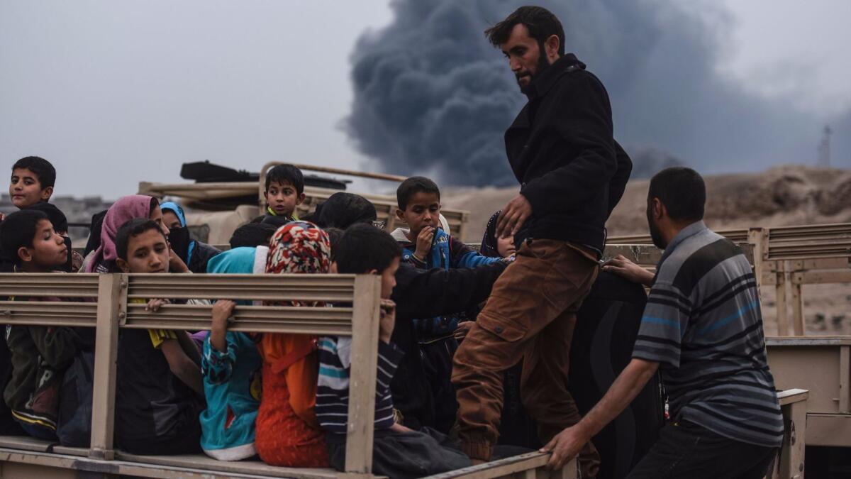 Families displaced by the Iraqi offensive to retake the city of Mosul from Islamic State gather near Qayyarah.