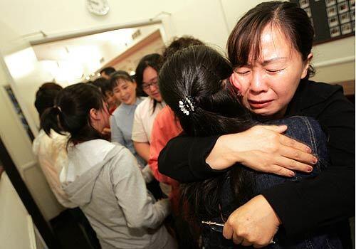 Members of Los Angeles Korean Methodist Church embrace North Korean refugee Na "Naomi" Omi (back to camera). Na Omi was one of several defectors brought through an underground railroad of safehouses and agents set up by the church's pastor, Chun Ki Won.