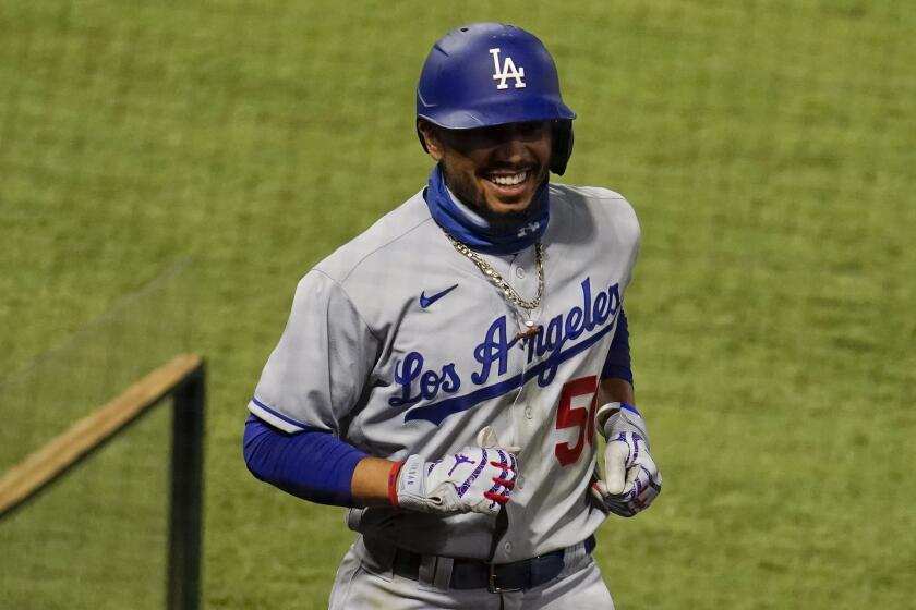 Los Angeles Dodgers' Mookie Betts smiles as he walks back to the dugout after his solo home run during the seventh inning of the team's baseball game against the Los Angeles Angels on Saturday, Aug. 15, 2020, in Anaheim, Calif. (AP Photo/Marcio Jose Sanchez)