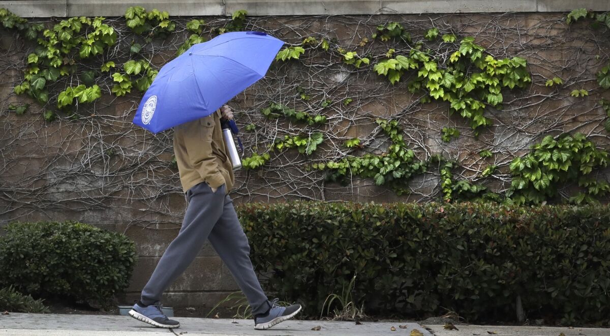 Southern California is preparing for rain expected to roll in to the area by Wednesday. In this May file photo, a pedestrian walks along Foothill Boulevard in La Crescenta under the cover of an umbrella during a rainstorm.