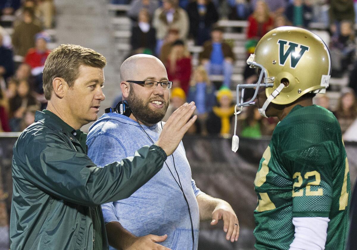 In this 2014 photo, "Woodlawn" director Andy Erwin talks with actors Caleb Castille and Nic Bishop 