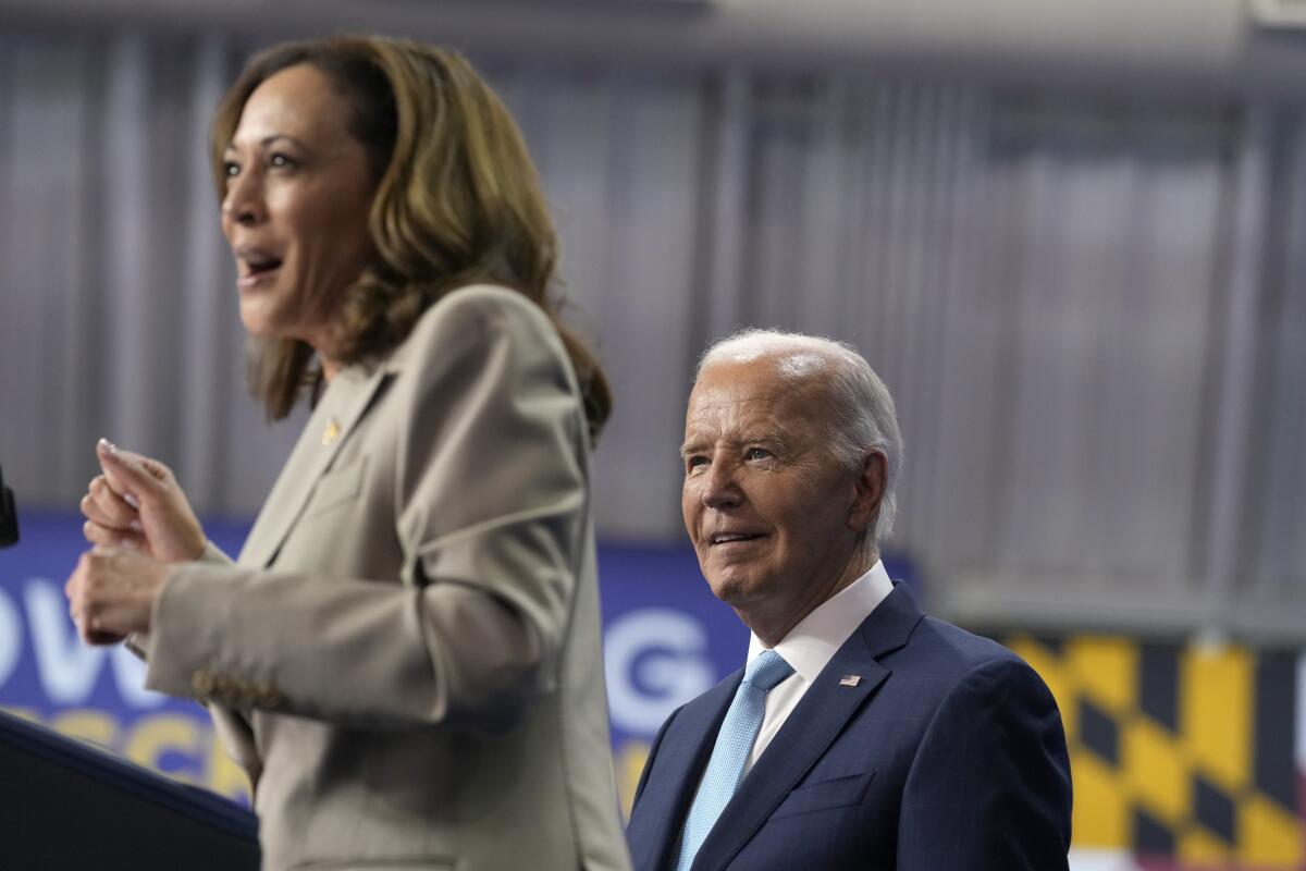 President Biden listens as Vice President Kamala Harris speaks about the administration's efforts to lower costs.