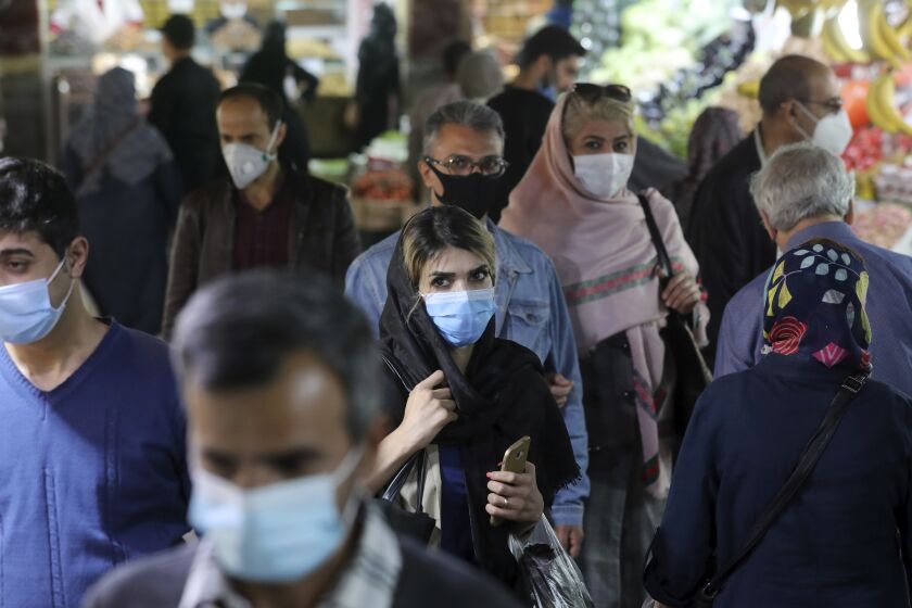 FILE - In this Oct. 15, 2020, file photo, people wear protective face masks to help prevent the spread of the coronavirus in the Tajrish traditional bazaar in northern Tehran, Iran. As a new wave of coronavirus infections engulfed Iran this month, filling hospitals and driving up the death toll, the country's health minister gave a rare speech criticizing the government's powerlessness to enforce basic health measures. (AP Photo/Ebrahim Noroozi, File)