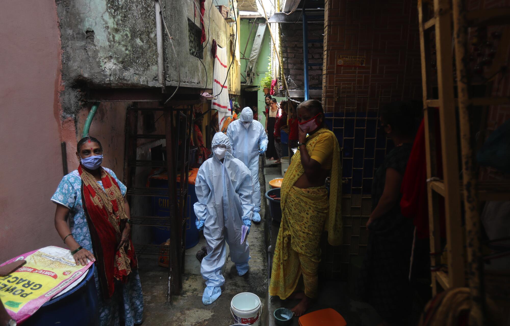 Health workers walk through Dharavi on June 20.
