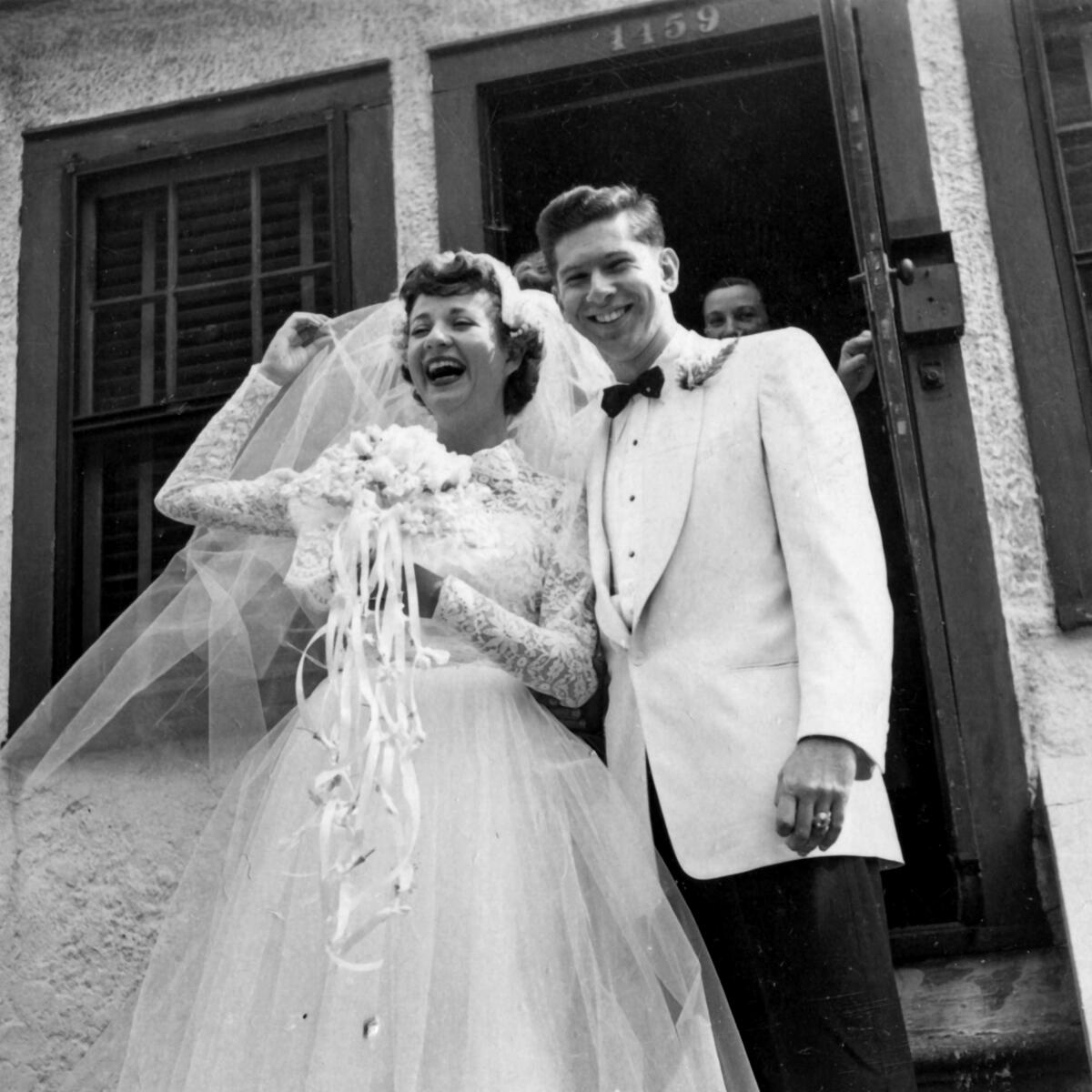 A black-and-white photo of a bride, left, and a groom