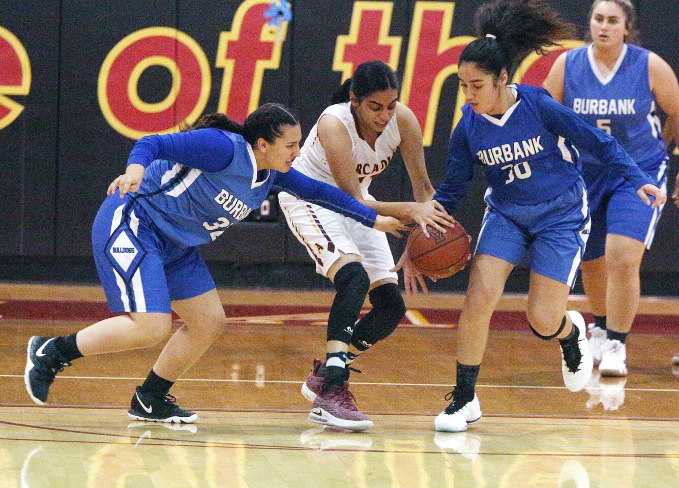 Burbank's Emily Monterey and Roxy Paynid steal the ball from Arcadia's Sahana Saikumar in a Pacific League girls' basketball game at Arcadia High School on Tuesday, December 4, 2018.