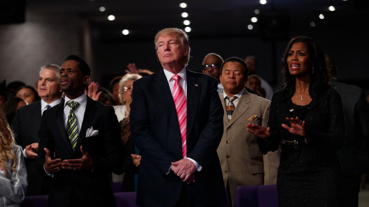 Republican presidential candidate Donald Trump, center, attends a church service at Great Faith Ministries in Detroit.