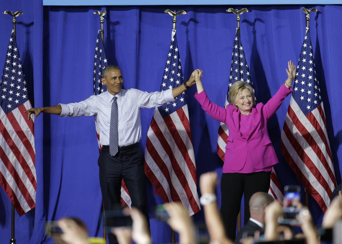 El presidente Barack Obama y la precandidata demócrata a la presidencia Hillary Clinton saludan a la multitud durante un acto de campaña en Charlotte, North Carolina, el martes 5 de julio de 2016. (AP Foto/Chuck Burton)