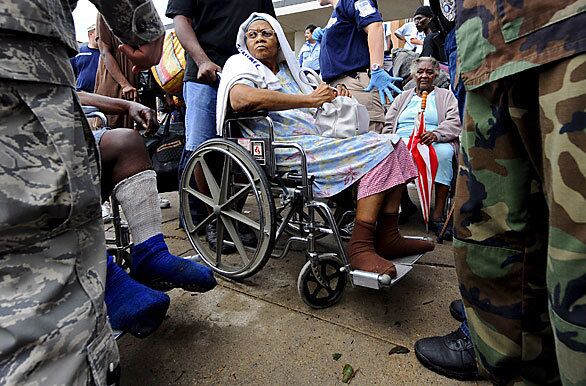 A woman sits in a wheelchair and waits for law officers and military to load her onto one of the buses for evacuation from the island of Galveston after Hurricane Ike made landfall.
