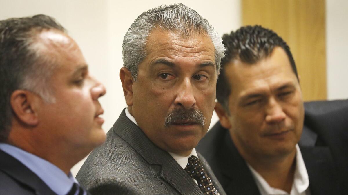 Tony Gamboa, center, President of United Firefighters of Los Angeles City with Freddy Escobar, left, Second Vice President and consultant Jimmy Blackman, right, listen to proceedings.