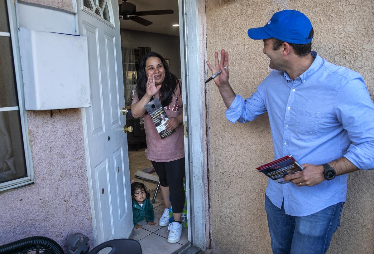 GOP candidate Matt Jacobs waves to voter Jacqueline Mercado in front of her home in Oxnard.