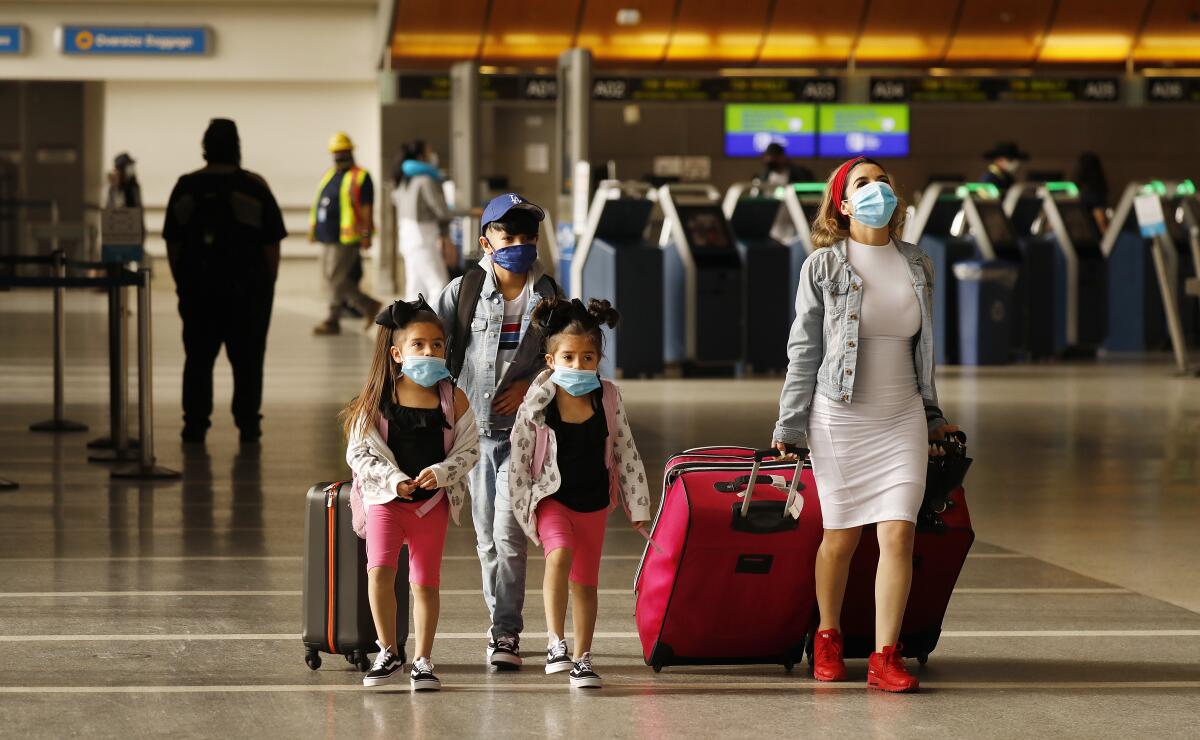 Travelers in an airport wearing face masks.
